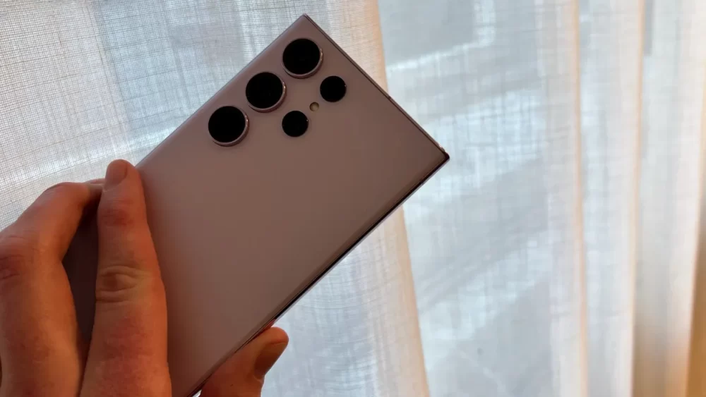 Beste mobil: En person holder en Samsung Galaxy S23 Ultra for å vise alle kameraene på baksiden