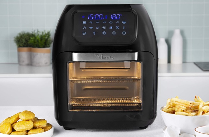 Airfryer test: En airfryer står på et hvitt bord ved siden av mat klart til fritering