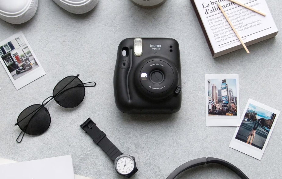 Beste polaroid-kamera: Et kamera ligger blant andre ting på et lyst underlag